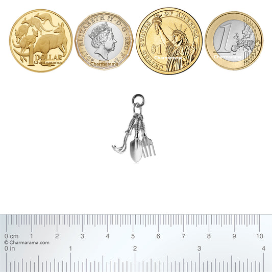 Sterling silver Gardening Tools charm with coins and ruler for scale on a white background