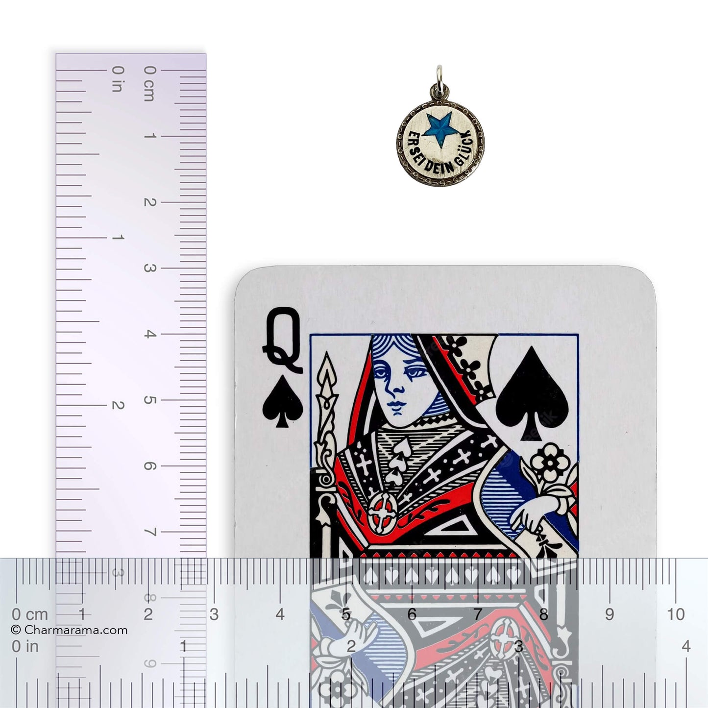 Austro-German lucky star charm next to a playing card with a ruler for scale