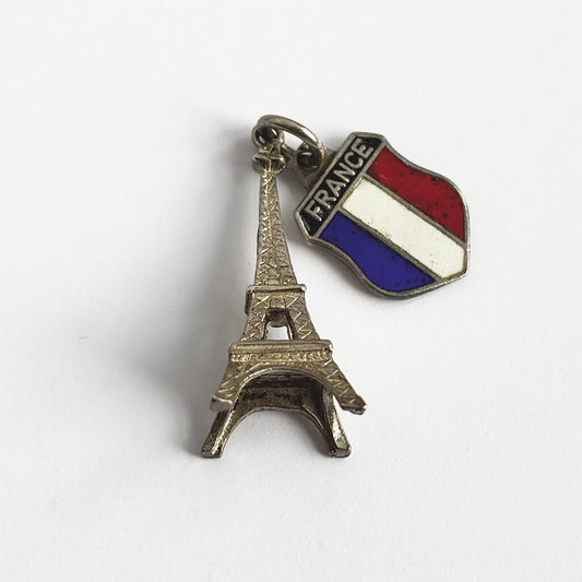 Silver charm with Eiffel Tower design and French flag on a white background