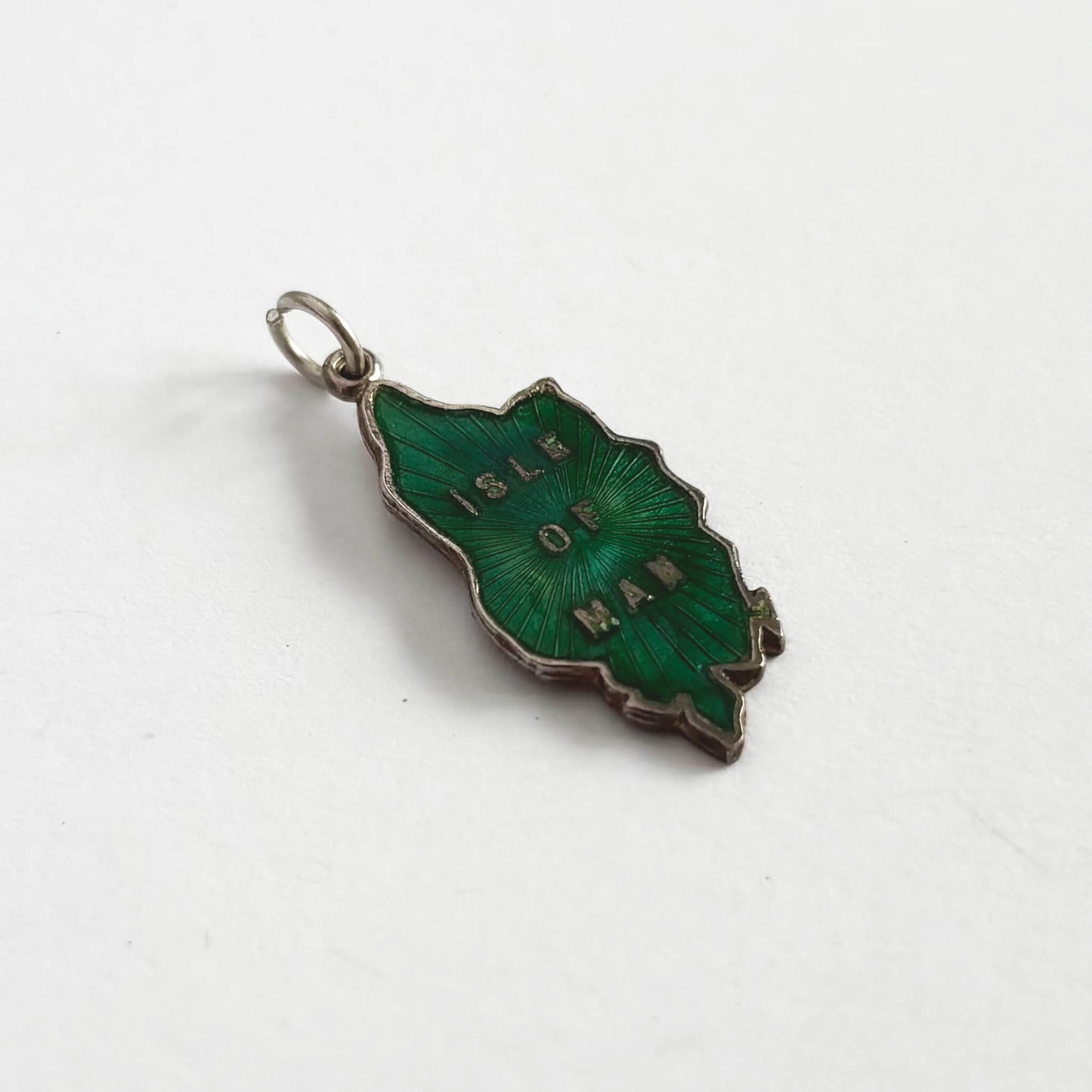 Green enamel pendant with 'Isle of Man' text on a white background
