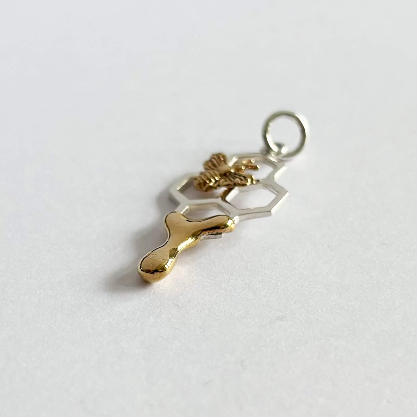 Honey bee on honeycomb charm in sterling silver and bronze