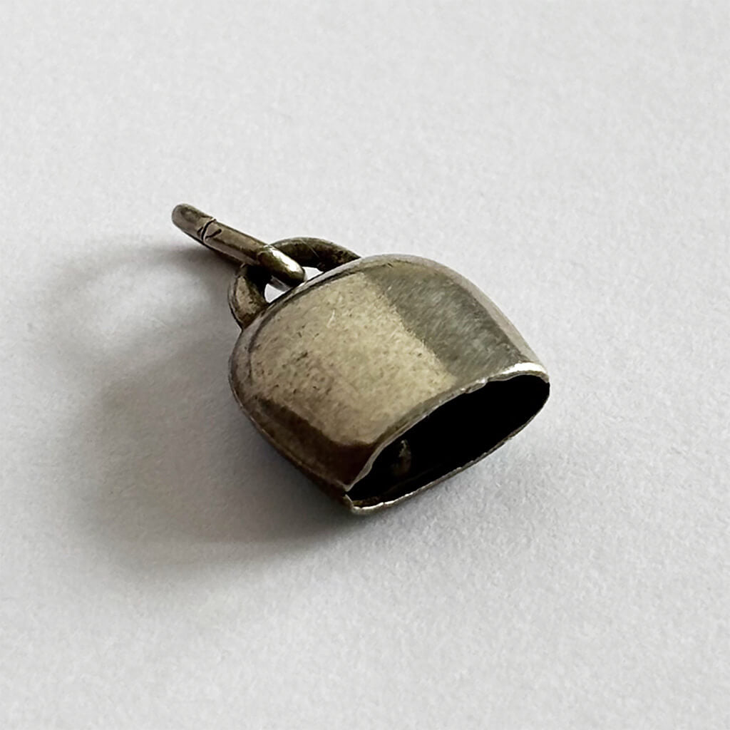 Vintage Silver Swiss Bell Charm with blue gentian flower on a white background