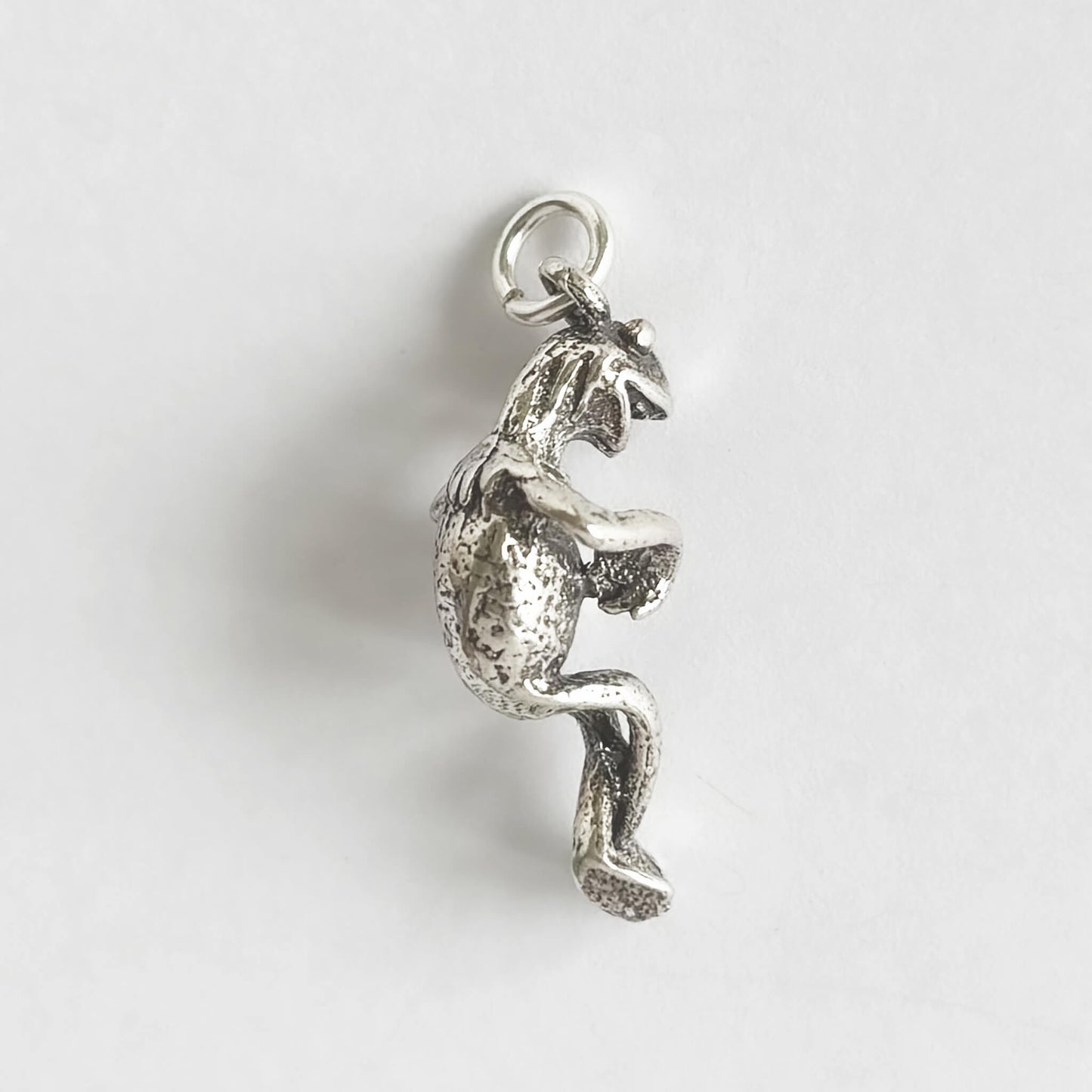 Silver kermit the frog pendant on a white background