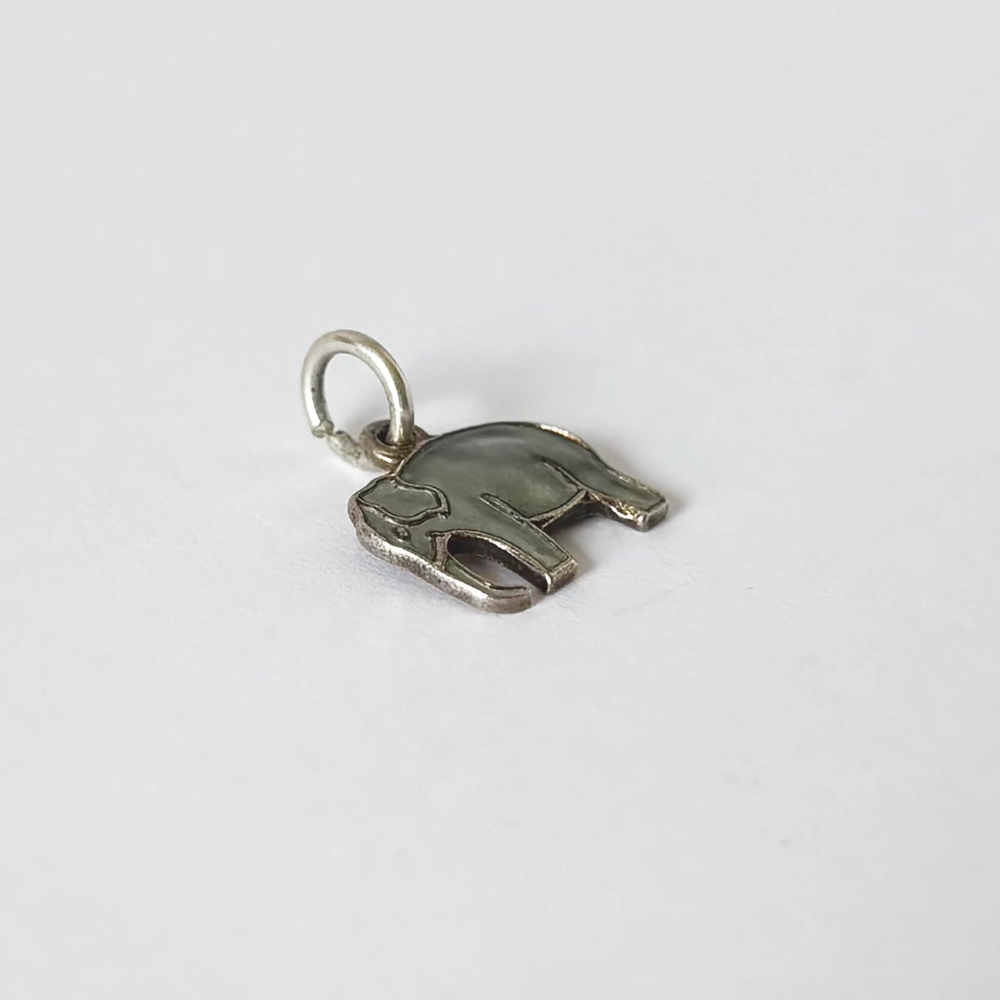 Silver elephant-shaped pendant on a white background
