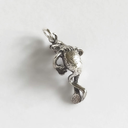 Silver pendant of a Kermit the frog figure on a white background