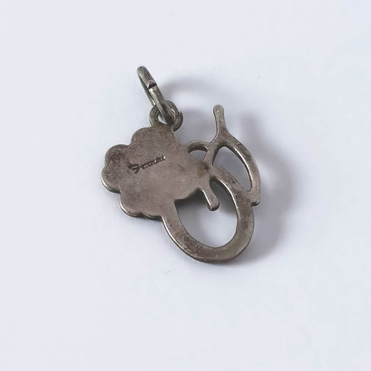 Silver pendant with a clover leaf design on a white background