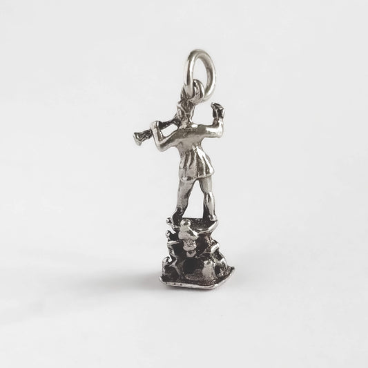 Silver pendant of a pied piper on a white background