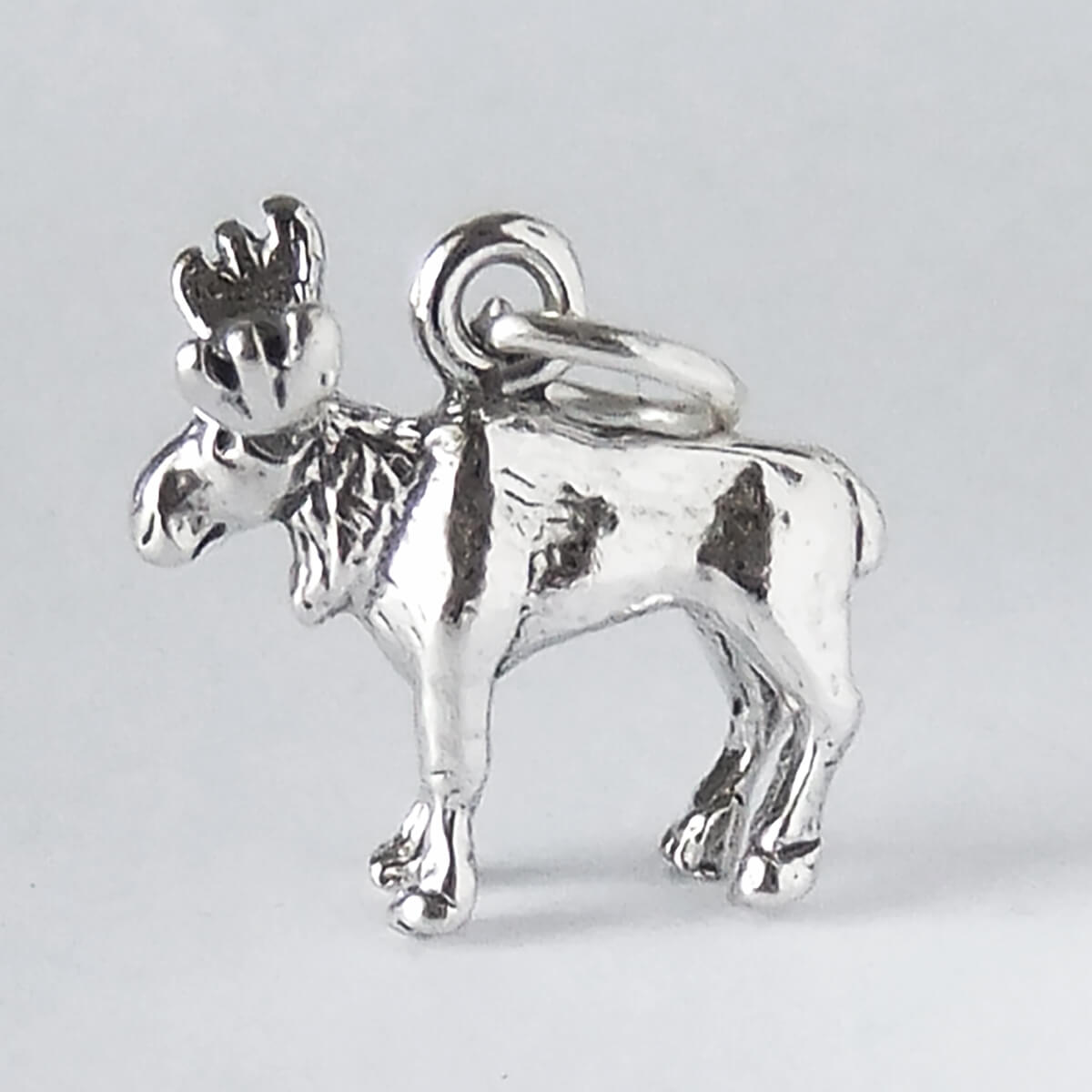 Silver moose charm on a light gray background