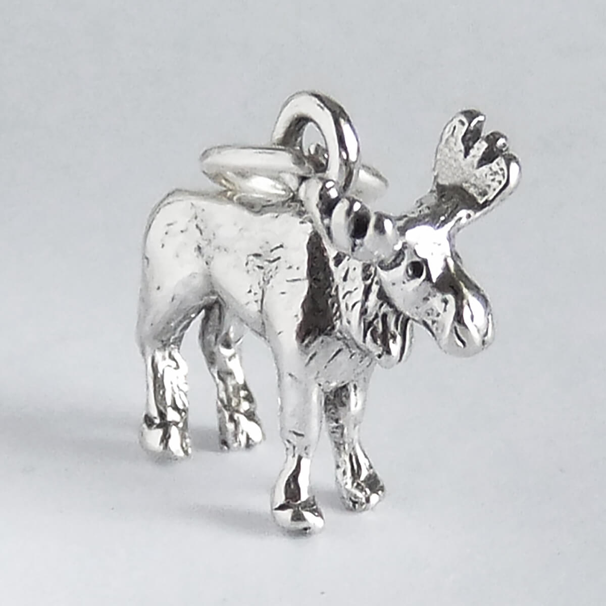 Silver moose charm on a light gray background