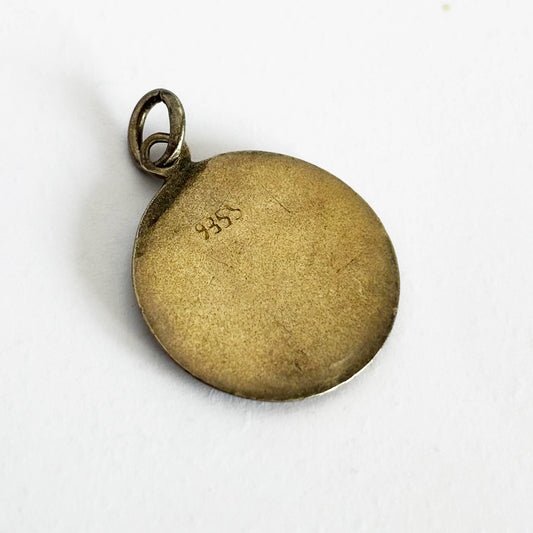 Gold pendant with '935' hallmark on a white background