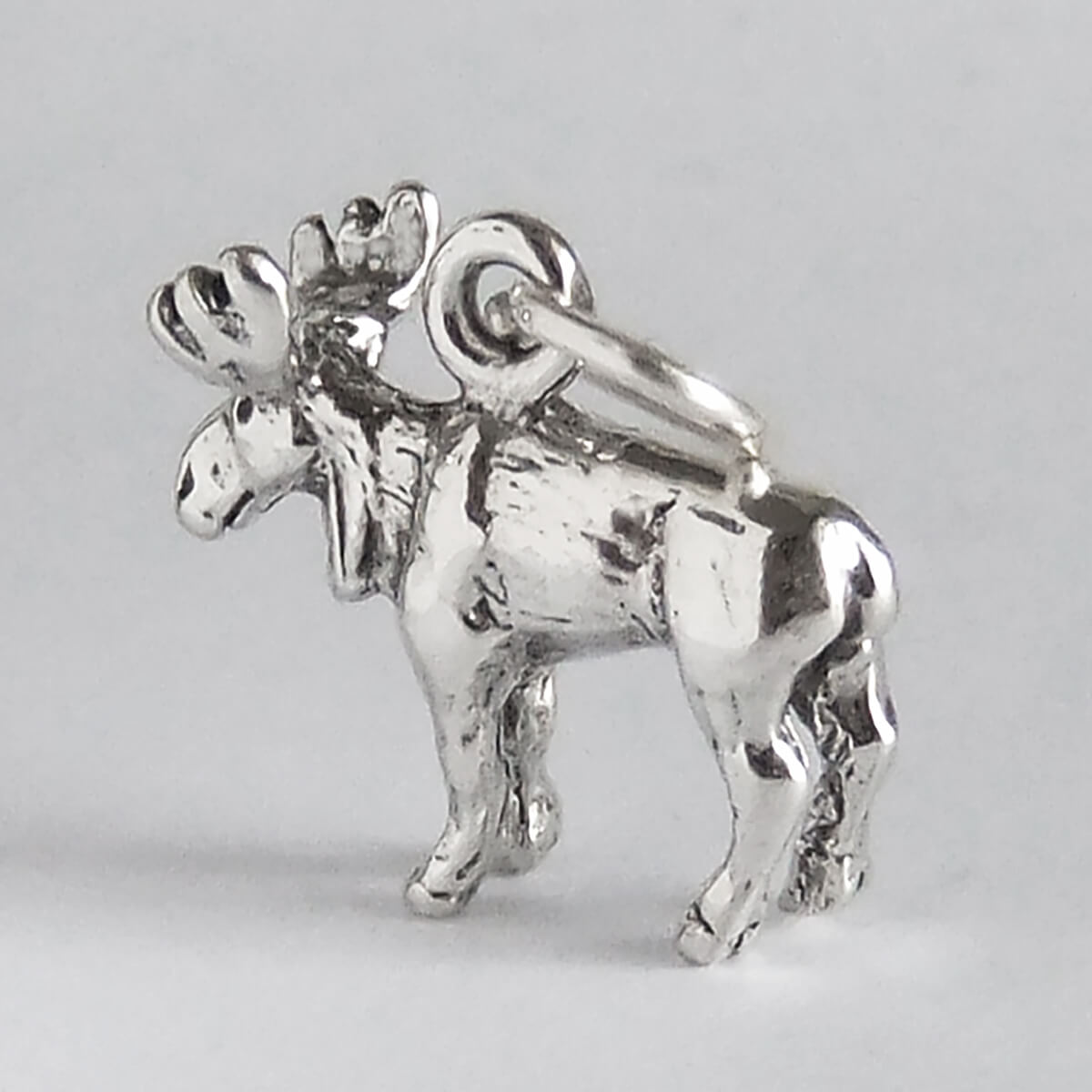 Silver moose charm on a light gray background