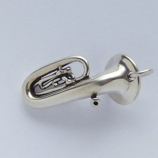 Silver tuba pendant on a light gray background
