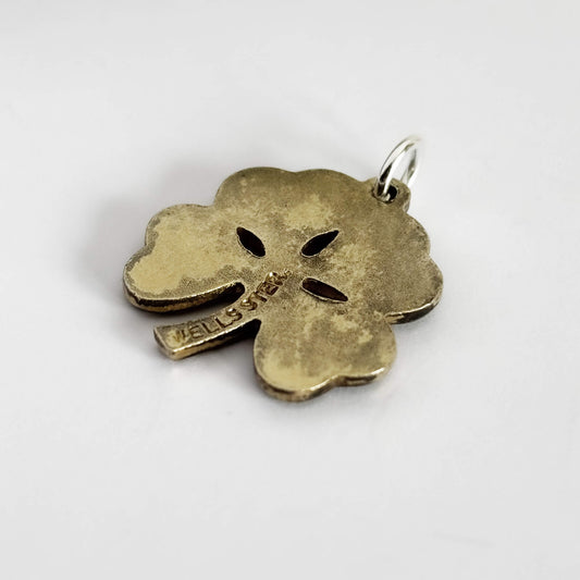 Back of a green four-leaf clover pendant on a white background