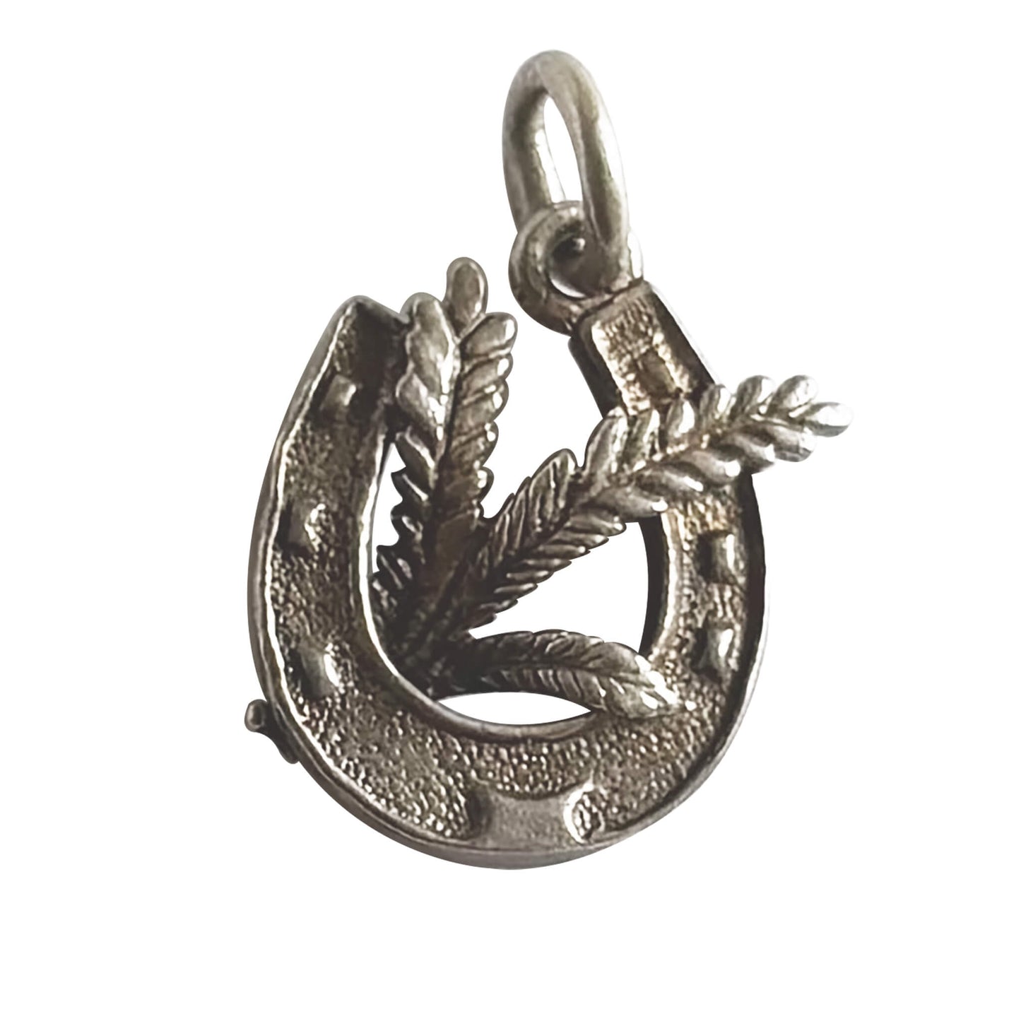 Silver horseshoe charm with heather leaves on a white background