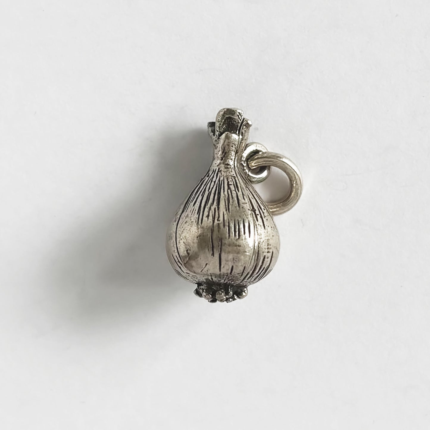 Silver onion charm on a white background