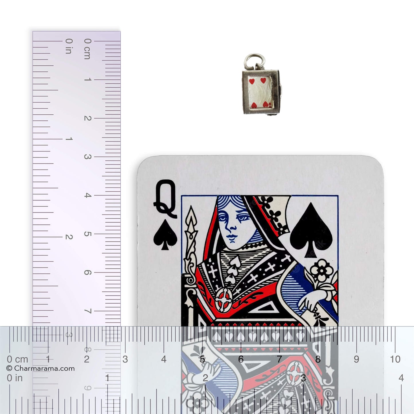 Vintage silver box of playing cards charm with a playing card and ruler for scale on a grey background