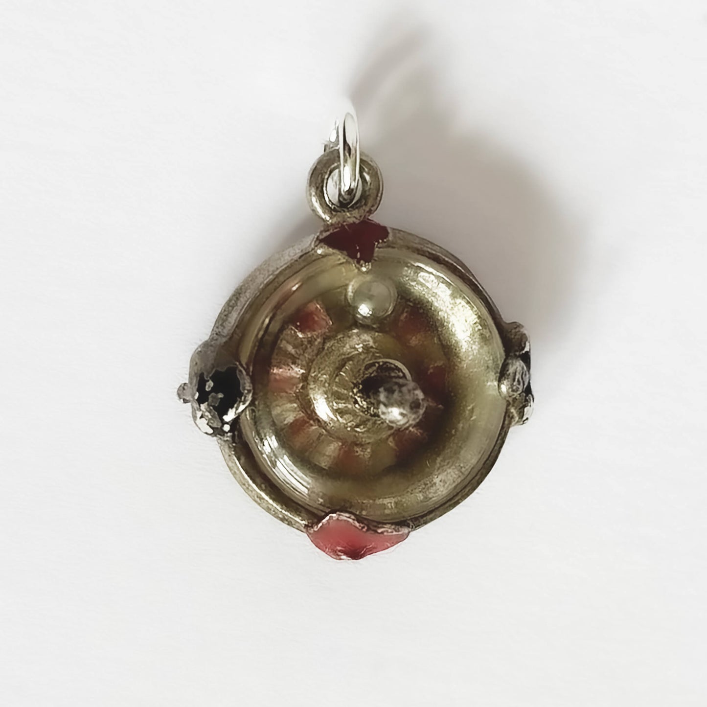 Silver roulette wheel charm pendant with red and black enamel on a white background