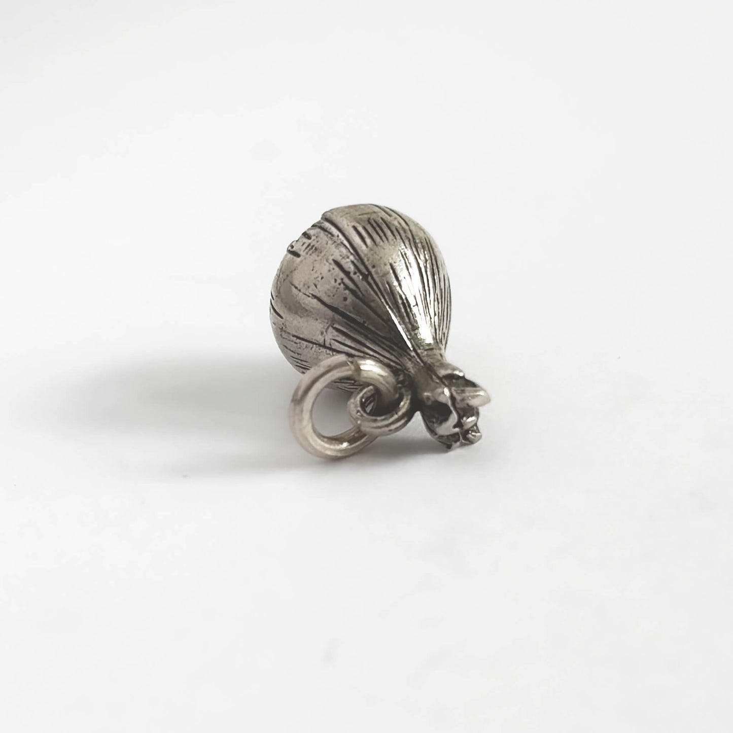 Silver onion charm on a white background