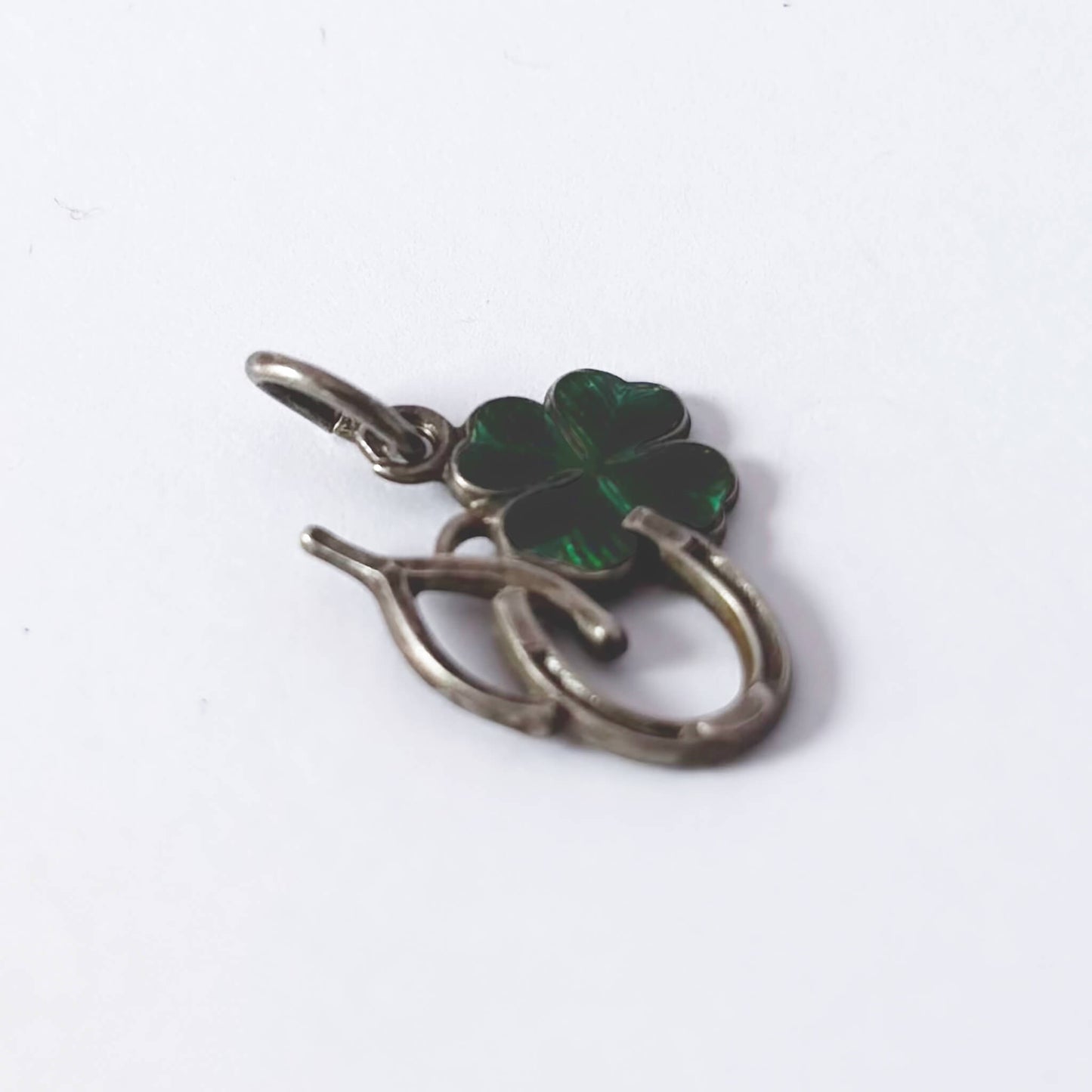 Four-leaf clover pendant with silver border on a white background