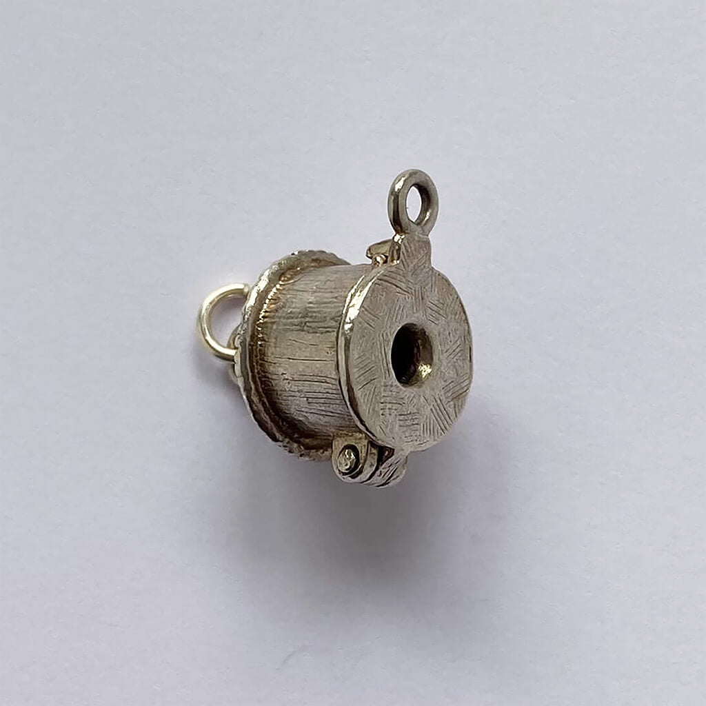 Mud hut opening to man in cauldron silver charm cannibal pendant