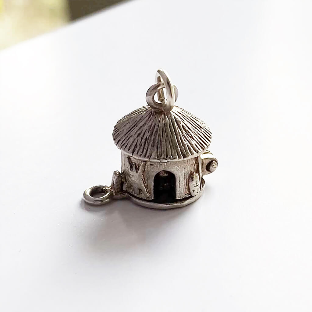 Mud hut opening to man in cauldron silver charm cannibal pendant