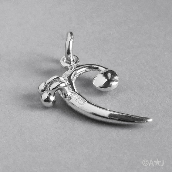 back of a silver bass clef charm on a grey background