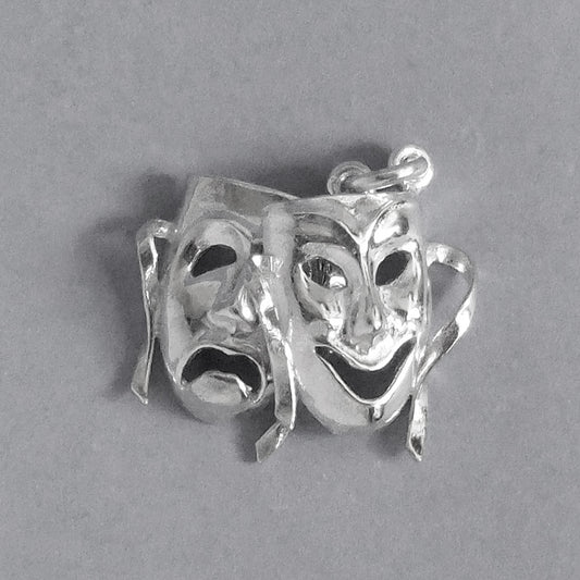 Sterling silver comedy and tragedy masks charm on a grey background