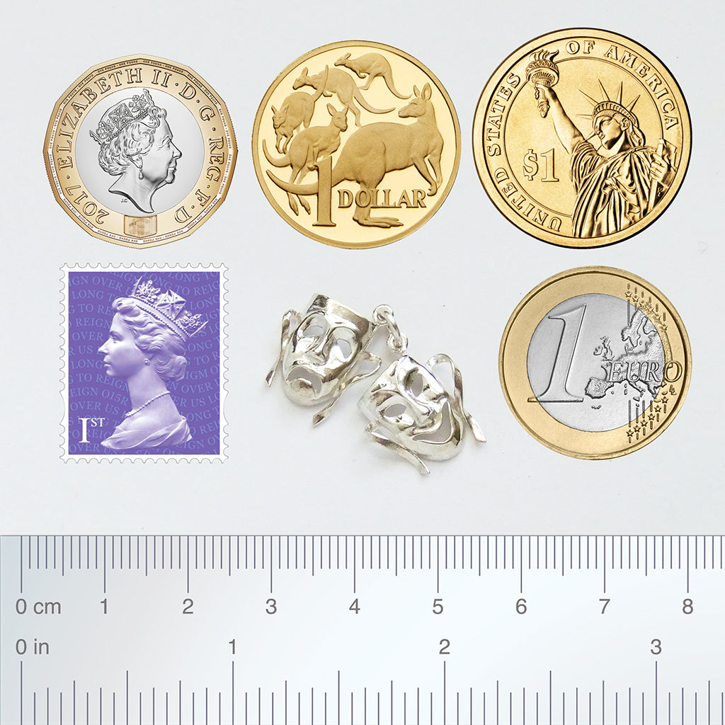 Sterling silver comedy and tragedy masks charm with coins stamp and ruler on a light grey background