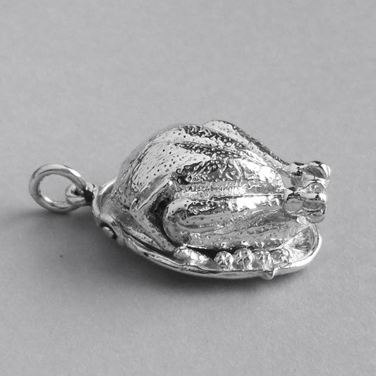 Sterling silver dressed turkey charm on a grey background