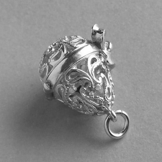 Sterling silver filigree egg charm on a grey background