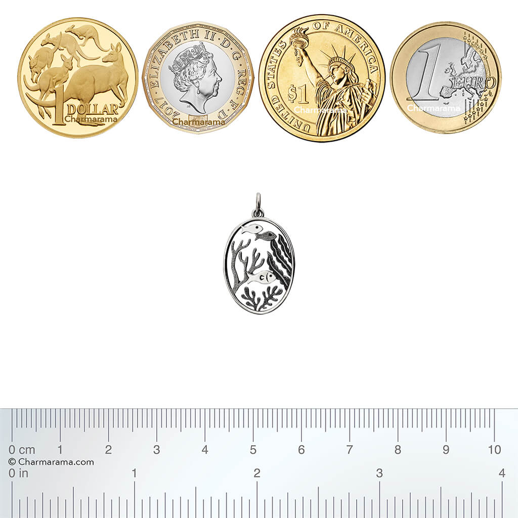 Sterling silver fish shoal charm with coins and ruler for scale on a white background