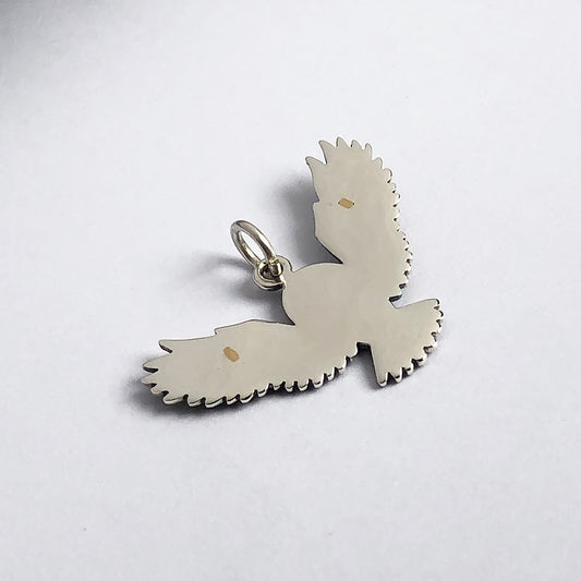 reverse view of sterling silver flying owl charm on a white background