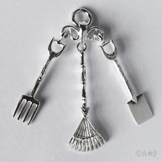 Sterling silver Garden Tools charm on a grey background