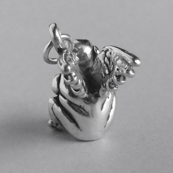 Back view of a sterling silver gargoyle charm on a grey background