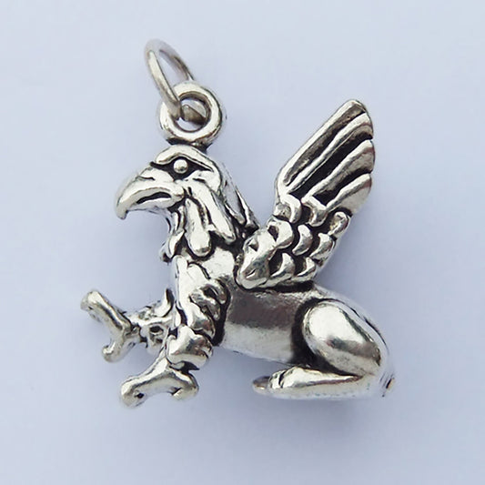 Sterling silver griffin charm on a light grey background