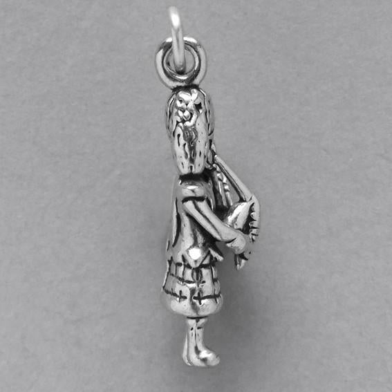 side view of silver bagpiper charm on grey background
