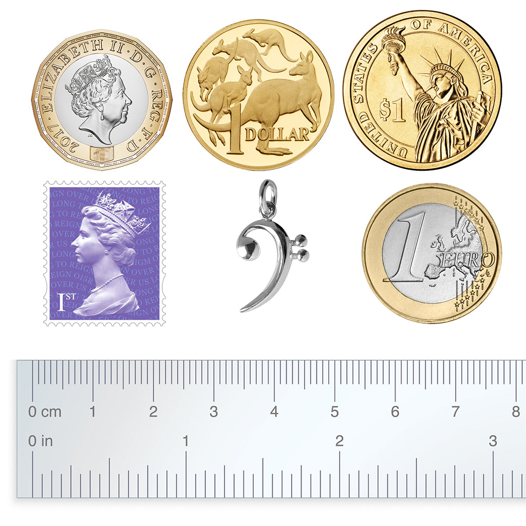 bass clef charm with coins and postage stamp for perspective