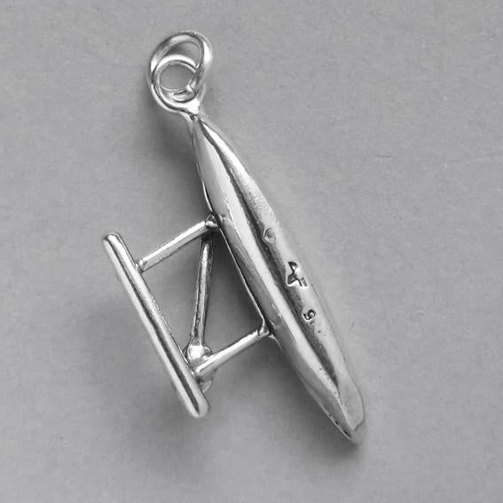 canoe and outrigger charm on grey background