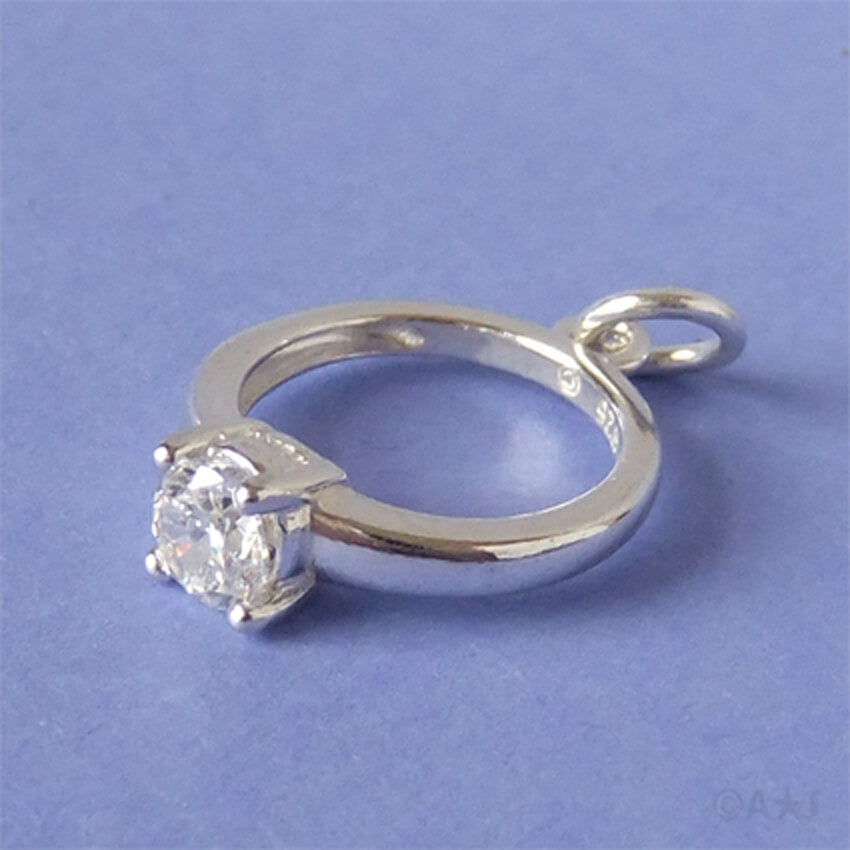 silver and crystal engagement ring charm on violet purple background