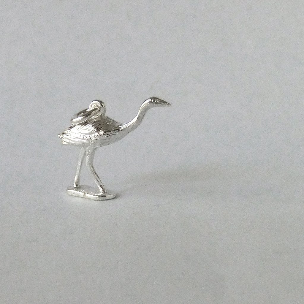 silver Australian brolga crane charm on a grey background