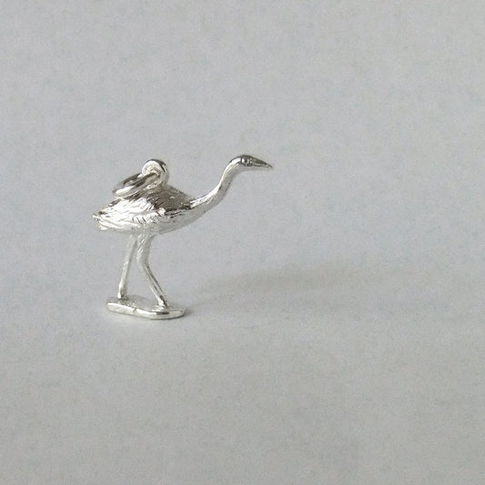 silver Australian brolga crane charm on a grey background