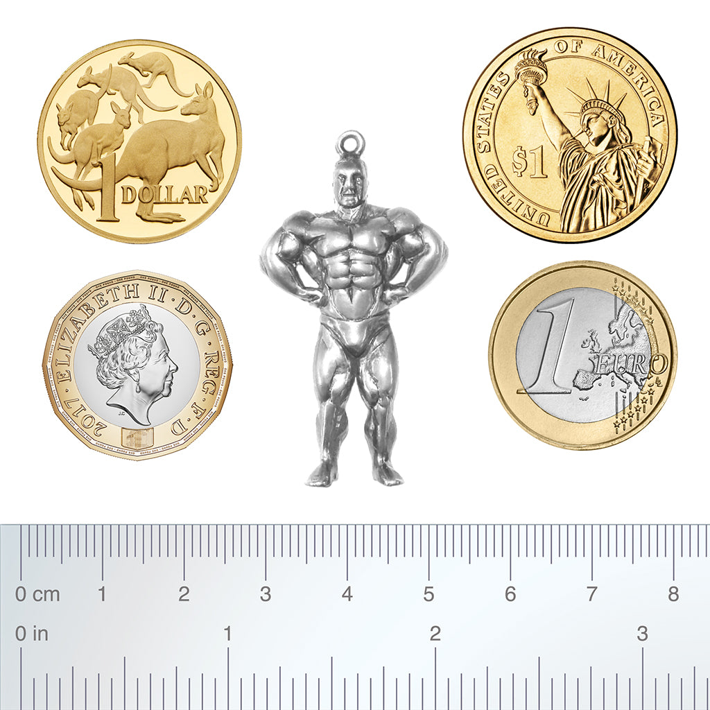 silver body builder pendant with coins and ruler for scale.