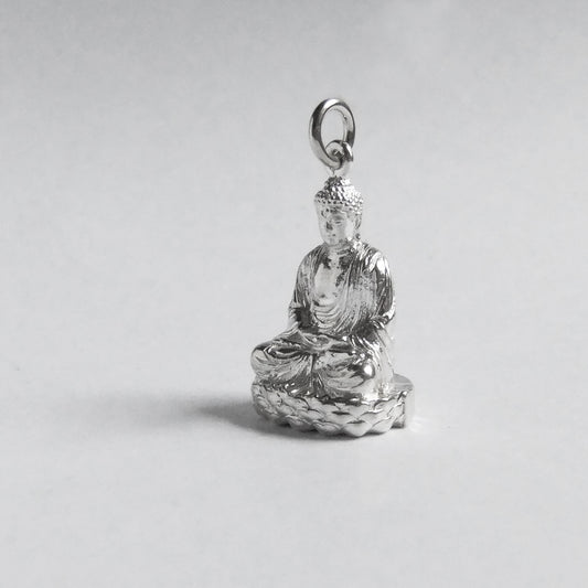 silver buddha charm on light grey background