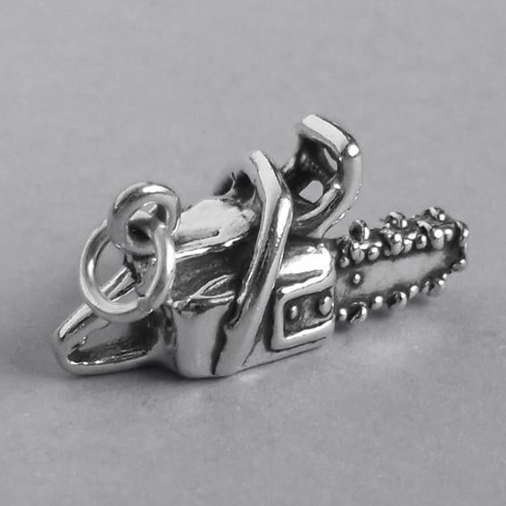 silver chainsaw charm pendant on a grey background