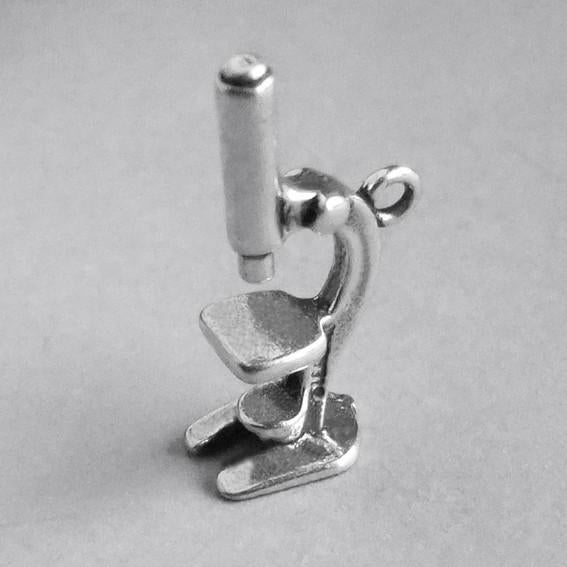 3D silver microscope charm on grey background