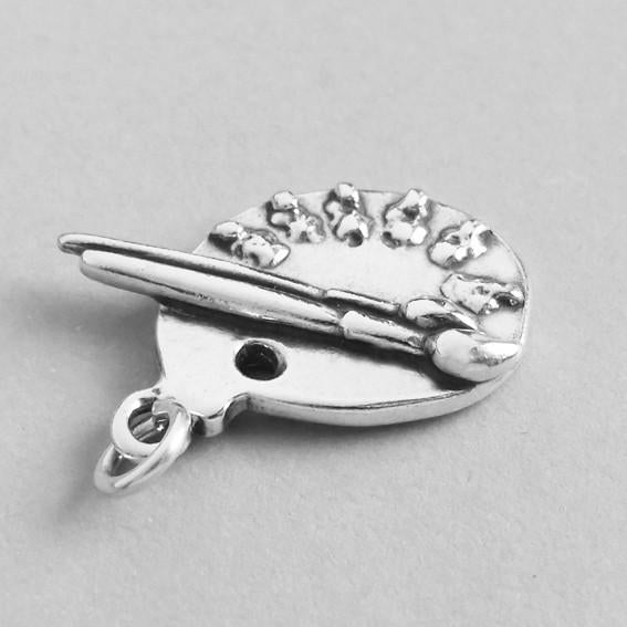 silver 3D paint palette charm on grey background