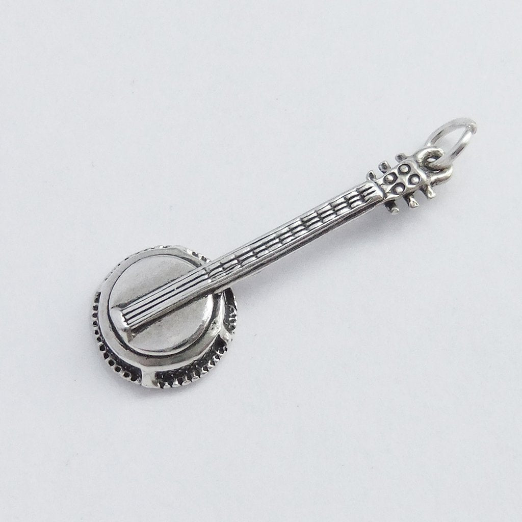 sterling silver banjo guitar pendant on light grey background