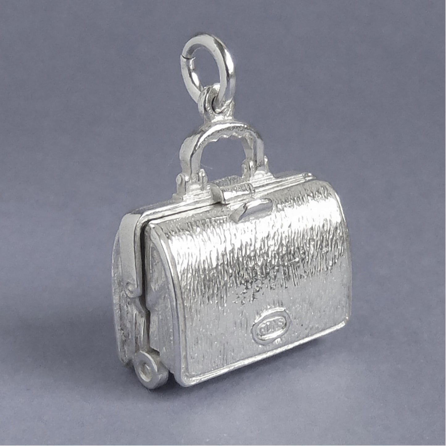 Sterling silver briefcase charm which opens to lingerie on a white background