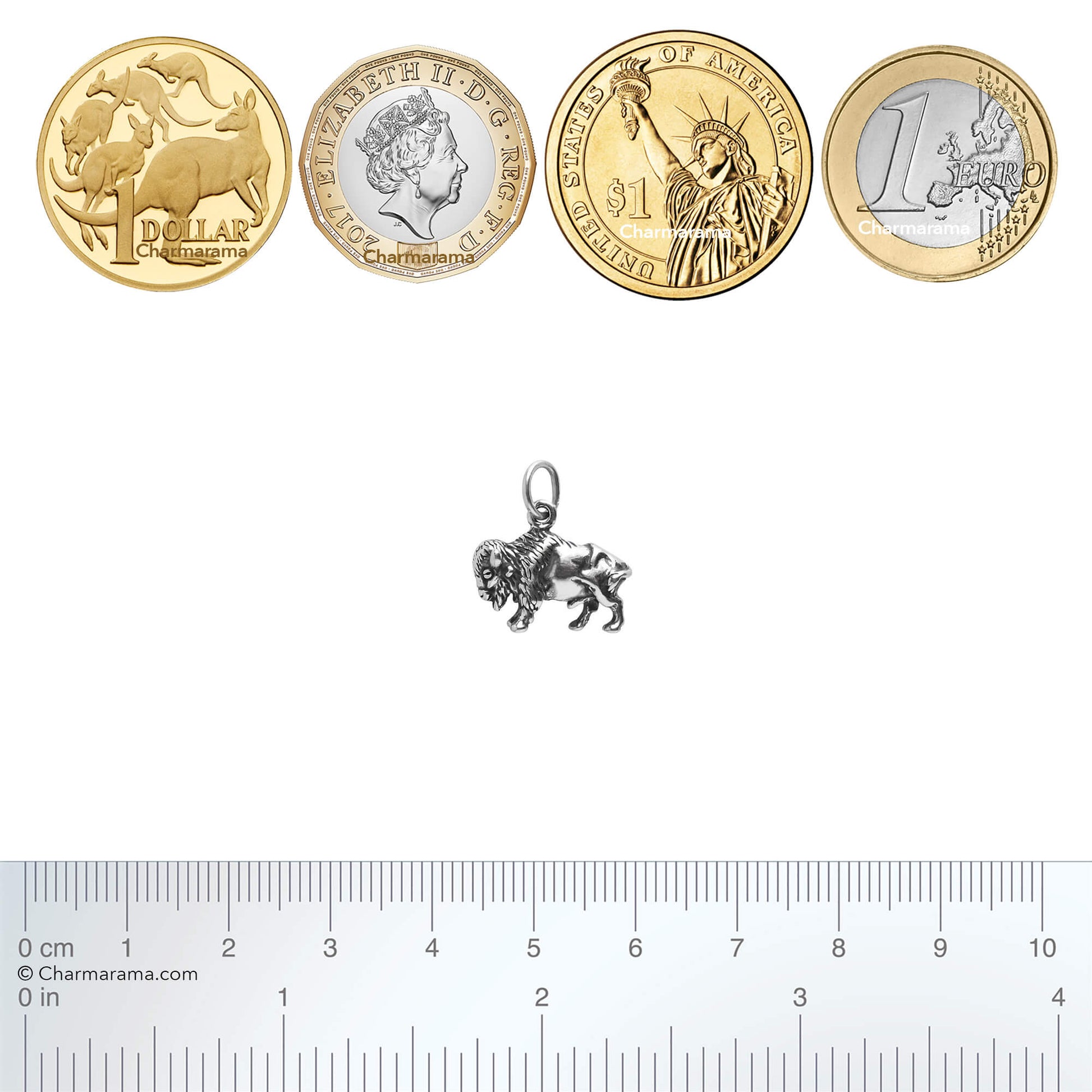 silver buffalo charm with coins and ruler for scale on a white background