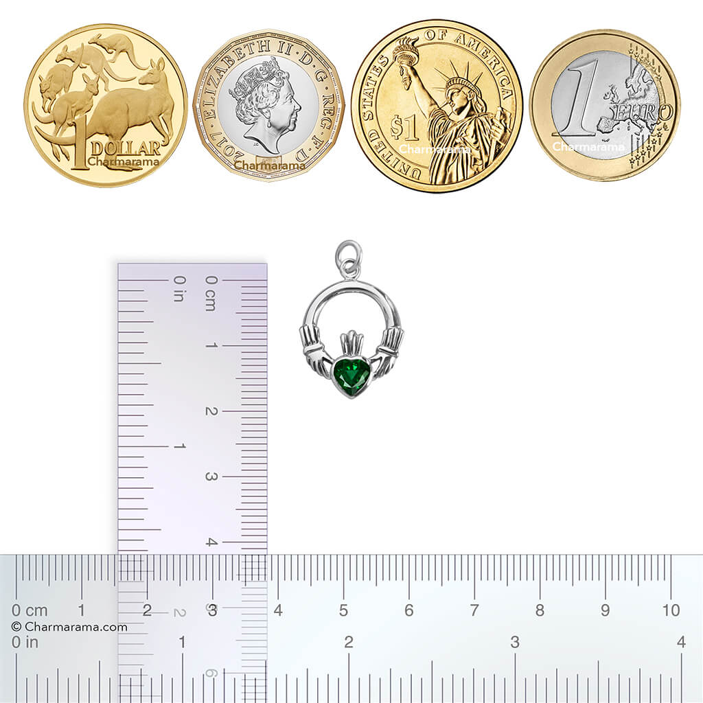 Sterling silver claddagh charm set with green crystal with coins and ruler for scale on white background